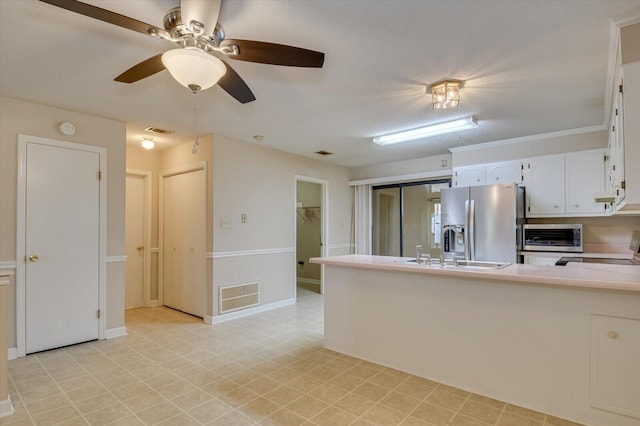 kitchen featuring visible vents, stainless steel fridge with ice dispenser, a peninsula, stove, and a sink