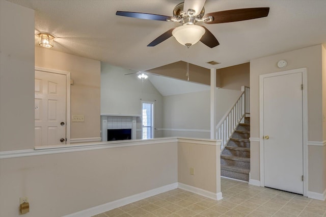 interior space featuring visible vents, stairway, baseboards, ceiling fan, and a tile fireplace