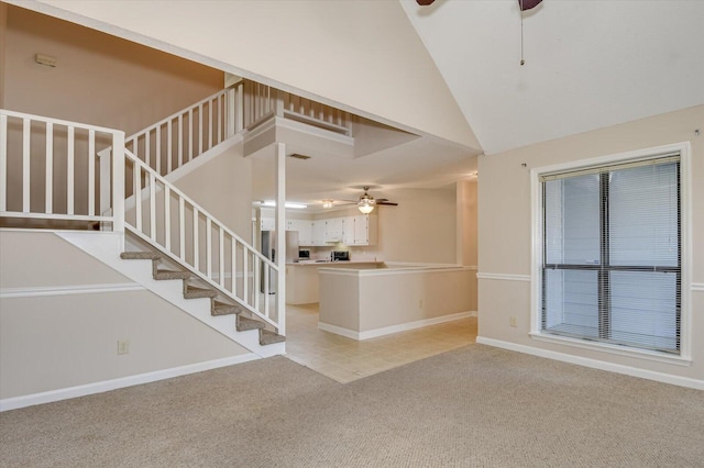 unfurnished living room featuring light carpet, high vaulted ceiling, a ceiling fan, stairway, and baseboards