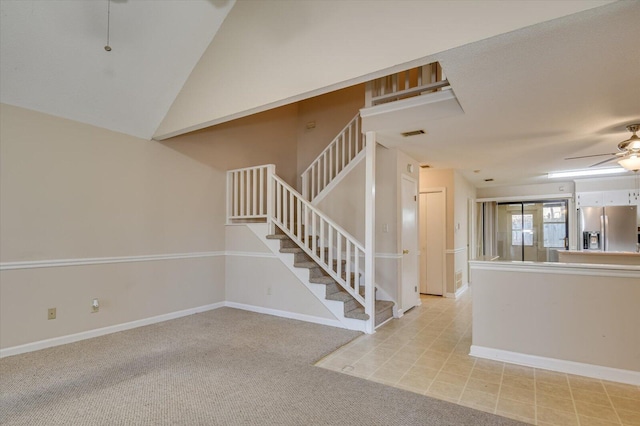 stairway with visible vents, baseboards, ceiling fan, vaulted ceiling, and carpet flooring