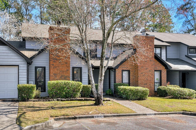 view of front of property featuring a front lawn, brick siding, roof with shingles, and a chimney