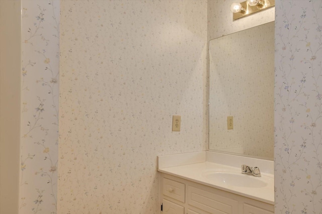 bathroom with vanity and wallpapered walls