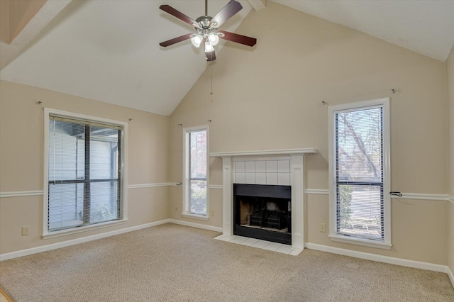 unfurnished living room with a tiled fireplace, carpet flooring, high vaulted ceiling, and baseboards