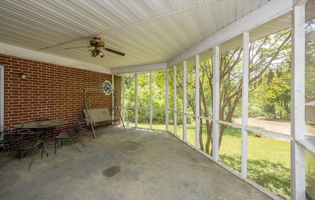 unfurnished sunroom with ceiling fan