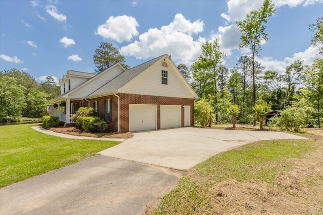 view of side of property with concrete driveway, a yard, and brick siding