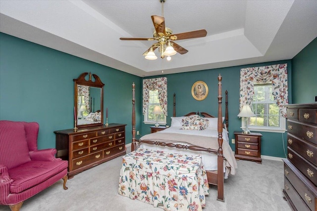 bedroom featuring baseboards, ceiling fan, carpet, and a tray ceiling
