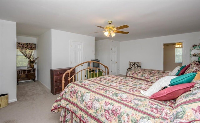 bedroom with a ceiling fan, baseboards, and light carpet