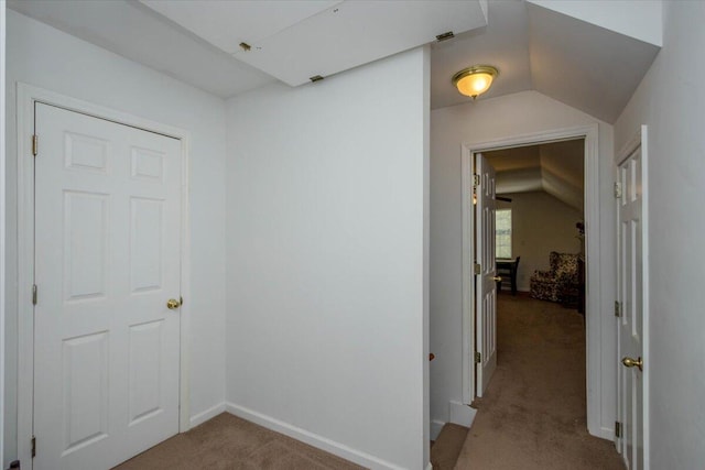 corridor featuring carpet flooring and lofted ceiling