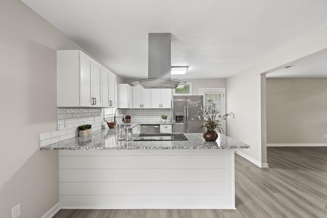 3630 Westhampton Dr, Augusta, GA 30907 - kitchen with appliances with stainless steel finishes, island exhaust hood, light stone counters, tasteful backsplash, and a peninsula