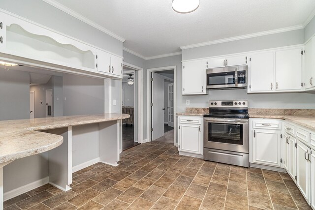 kitchen with white cabinets, crown molding, stainless steel appliances, and a textured ceiling