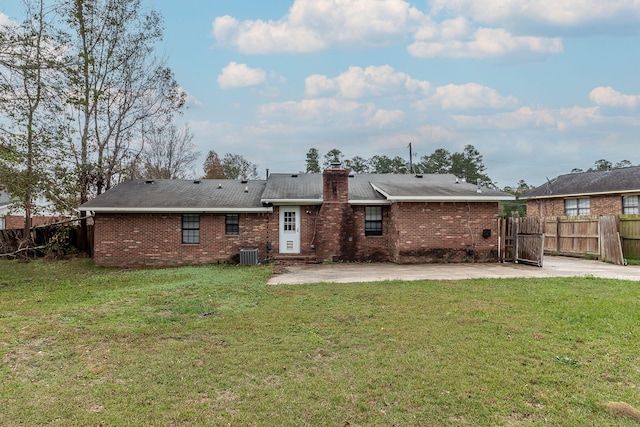 back of property with a yard, a patio, and central AC