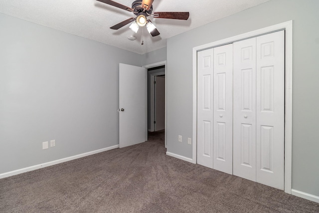 unfurnished bedroom with a textured ceiling, carpet floors, a closet, and ceiling fan