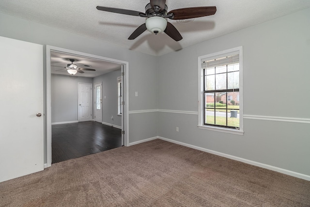 carpeted empty room featuring a wealth of natural light, ceiling fan, and a textured ceiling