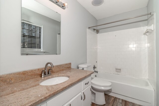 full bathroom featuring toilet, hardwood / wood-style floors, vanity, and washtub / shower combination