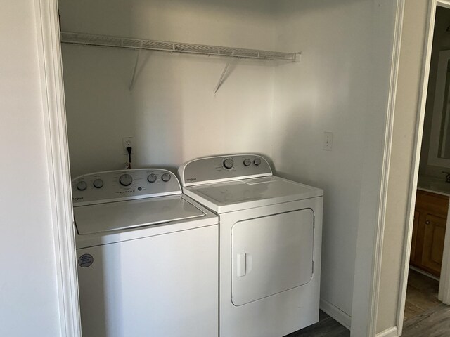 laundry room featuring hardwood / wood-style flooring and washer and dryer