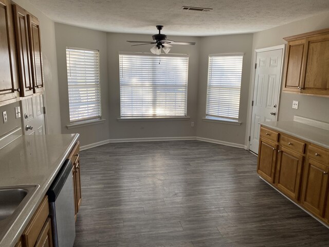 unfurnished dining area featuring a textured ceiling, ceiling fan, sink, and dark wood-type flooring