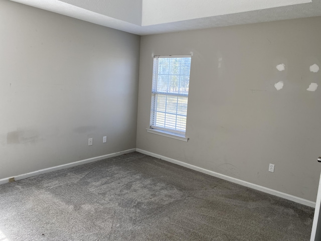 spare room with dark carpet