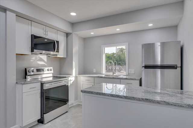 2417 Wilkshire Dr, Augusta, GA 30904 - kitchen with white cabinetry, a sink, light stone countertops, and appliances with stainless steel finishes