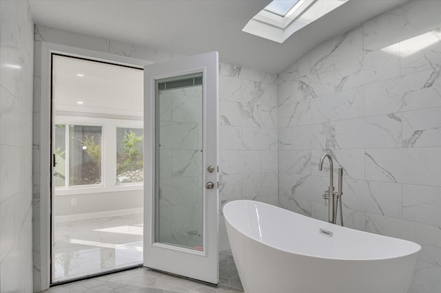 2417 Wilkshire Dr, Augusta, GA 30904 - full bath with a soaking tub, lofted ceiling with skylight, tile walls, and marble finish floor