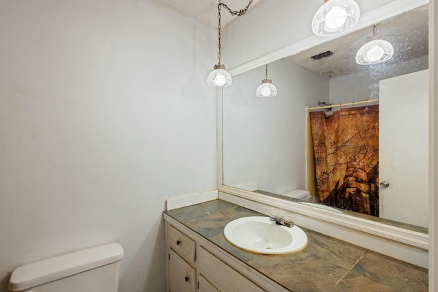 bathroom featuring vanity, a textured ceiling, and toilet