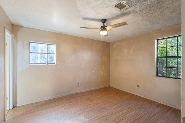 unfurnished room featuring ceiling fan, light hardwood / wood-style flooring, and a textured ceiling