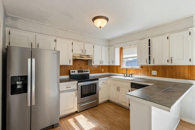 kitchen with sink, light hardwood / wood-style flooring, appliances with stainless steel finishes, white cabinets, and kitchen peninsula