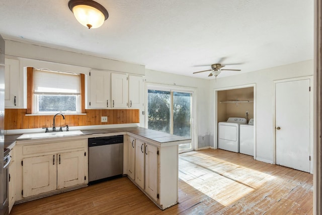 kitchen featuring sink, washer and clothes dryer, dishwasher, kitchen peninsula, and light wood-type flooring