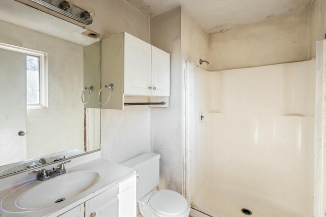 bathroom with walk in shower, vanity, and toilet