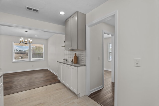 kitchen with backsplash, hanging light fixtures, and a notable chandelier