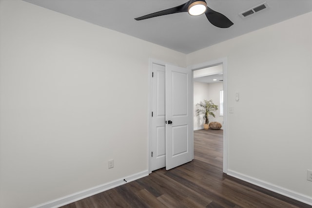 empty room with dark hardwood / wood-style flooring and ceiling fan