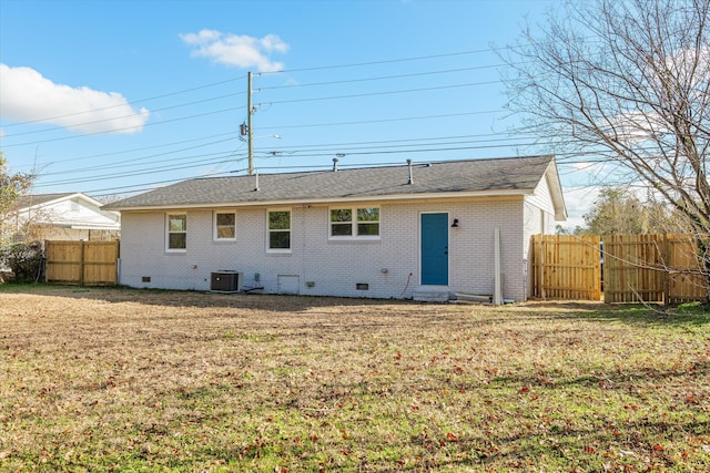 rear view of property with a yard and central AC unit