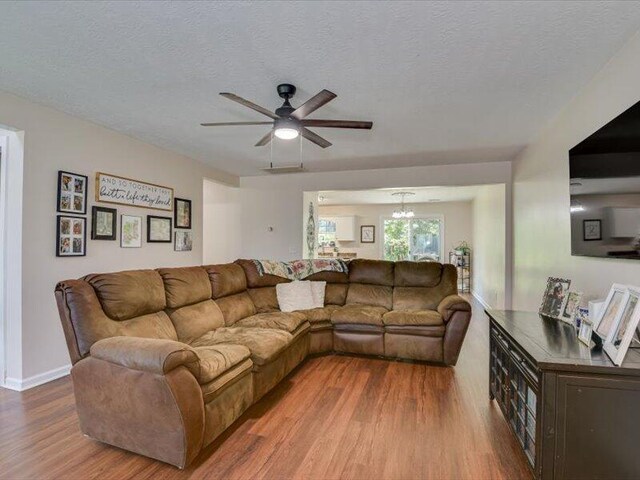 2084 Gardenview Dr, Graniteville, SC 29829 - living room featuring wood finished floors, a ceiling fan, a textured ceiling, and a chandelier