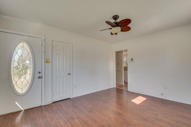 foyer with crown molding, ceiling fan, dark hardwood / wood-style floors, and a textured ceiling