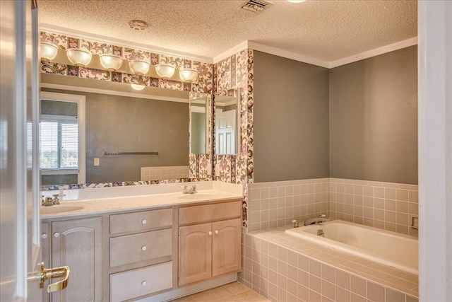 bathroom featuring tile patterned floors, vanity, a textured ceiling, and tiled bath