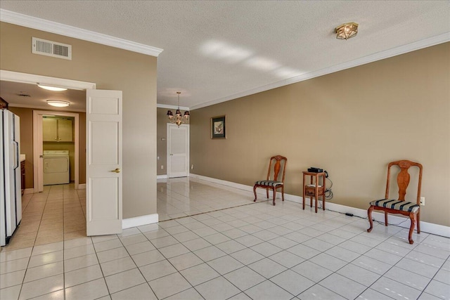 unfurnished room with crown molding, light tile patterned floors, a textured ceiling, and washer / dryer