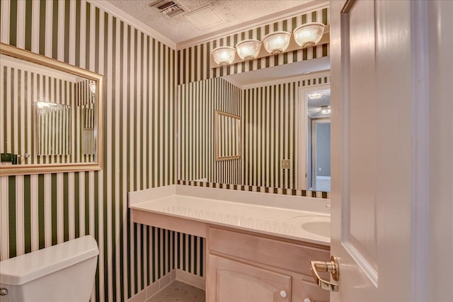 bathroom with vanity, a textured ceiling, crown molding, tile patterned flooring, and toilet