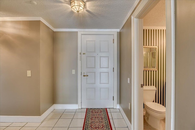 tiled entryway with ornamental molding and a textured ceiling