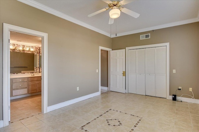 unfurnished bedroom featuring ceiling fan, crown molding, light tile patterned floors, and ensuite bathroom