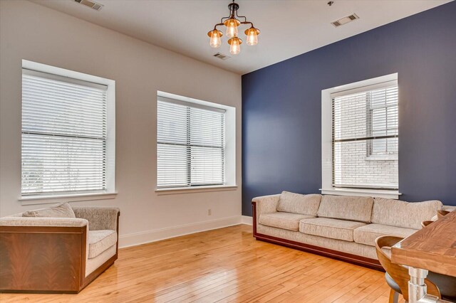 living room featuring light hardwood / wood-style floors, plenty of natural light, and a notable chandelier