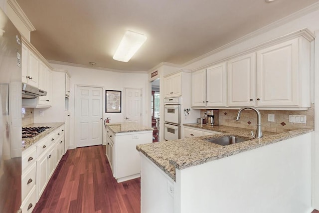 249 Calloway Dr, Evans, GA 30809 - kitchen with white double oven, a center island, dark wood-type flooring, stainless steel gas stovetop, and decorative backsplash