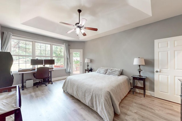 249 Calloway Dr, Evans, GA 30809 - bedroom featuring a tray ceiling, access to exterior, a desk, wood finished floors, and a ceiling fan