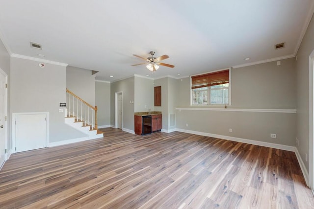 249 Calloway Dr, Evans, GA 30809 - unfurnished living room featuring stairs, ceiling fan, light wood-style floors, beverage cooler, and crown molding