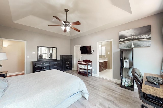 249 Calloway Dr, Evans, GA 30809 - bedroom featuring a tray ceiling, light wood-style flooring, connected bathroom, and ceiling fan