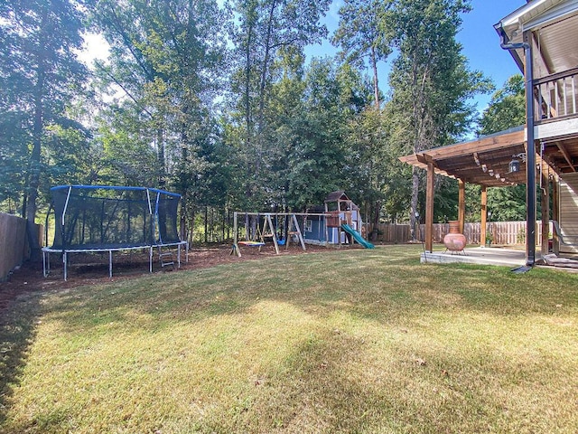 1410 Summit Way, Grovetown, GA 30813 - fenced backyard with a trampoline, a playground, and a patio area
