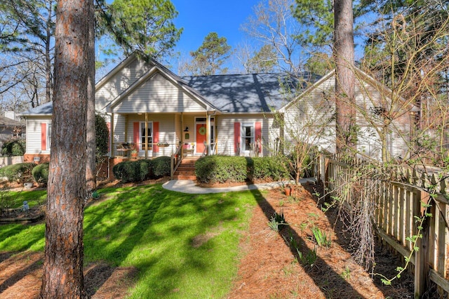 view of front of property featuring a front yard, fence, and covered porch