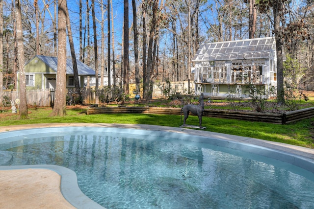 view of pool with an outbuilding, a fenced in pool, fence, and a lawn