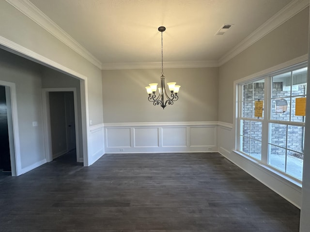 unfurnished dining area featuring dark hardwood / wood-style flooring, crown molding, and a notable chandelier