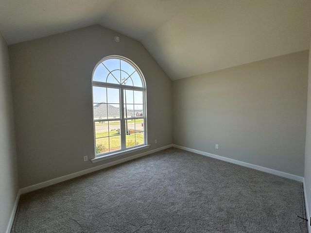 carpeted spare room with lofted ceiling