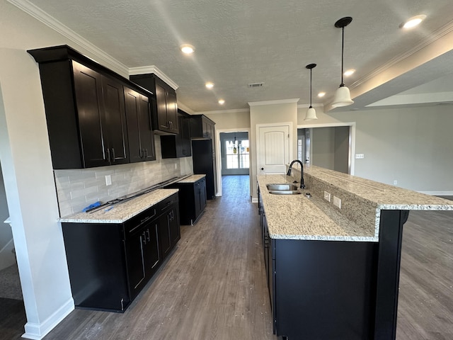 kitchen with pendant lighting, dark wood-type flooring, a spacious island, sink, and tasteful backsplash