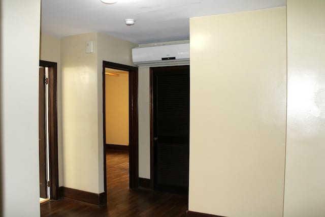 corridor featuring a wall mounted air conditioner and dark hardwood / wood-style floors